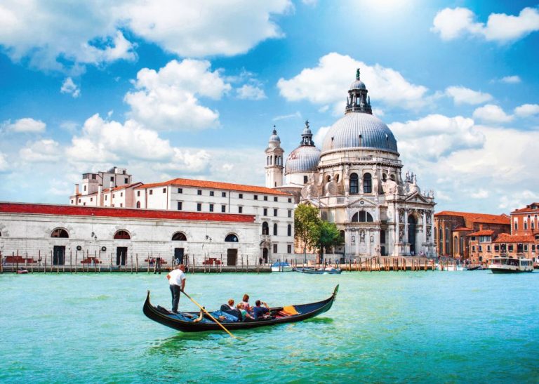 Vznešeně pluje gondola s turisty kolem chrámu Santa Maria della Salute ve čtvrti Dorsorudo.