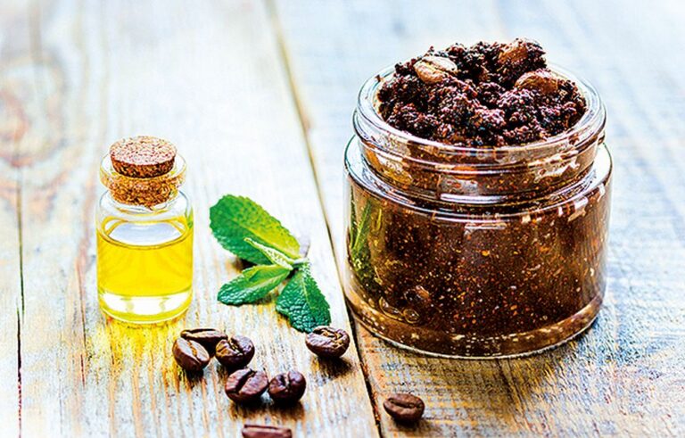 Homemade cosmetics with coffee scrub and oil on wooden desk background