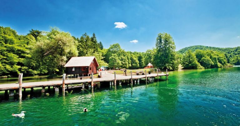 Dřevěné chodníčky nad smaragdovou vodou, to jsou Plitvice.